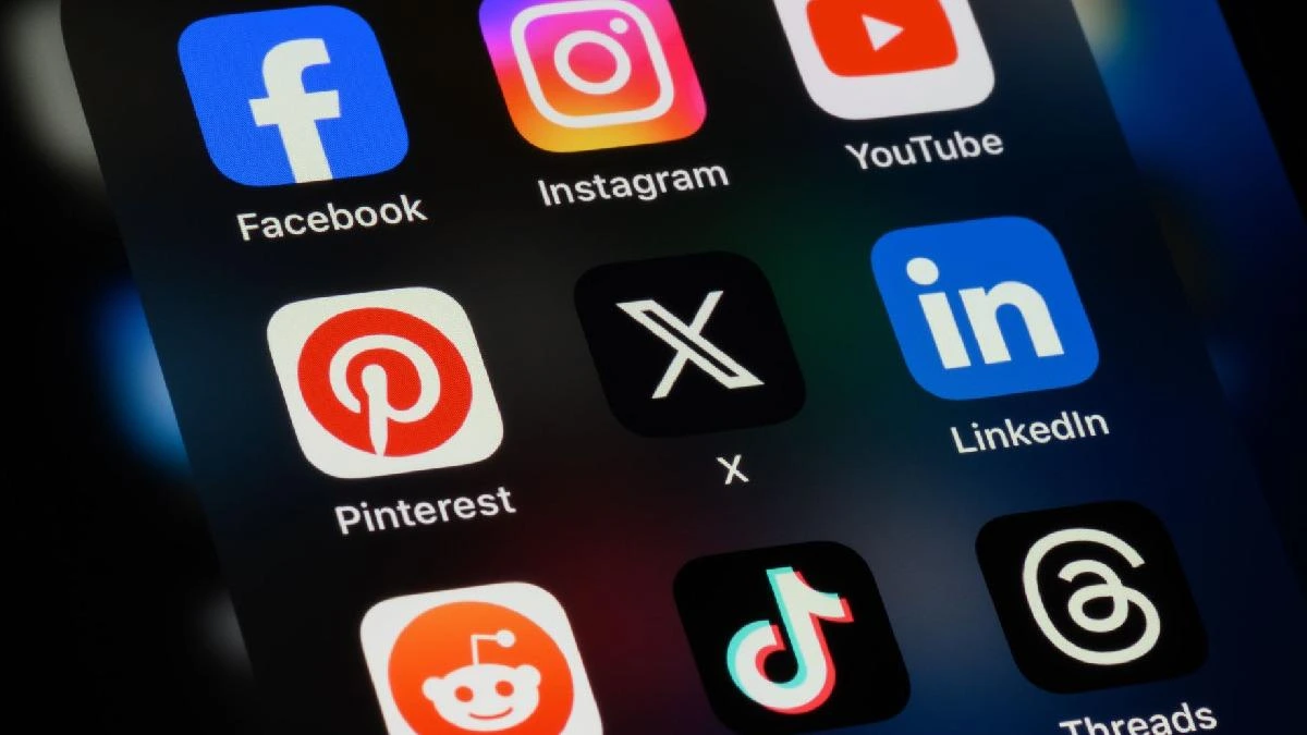 Bir telefonda Facebook, Instagram, YouTube, Pinterest, X, LinkedIn, Reddit, TikTok ve Threads simgeleri