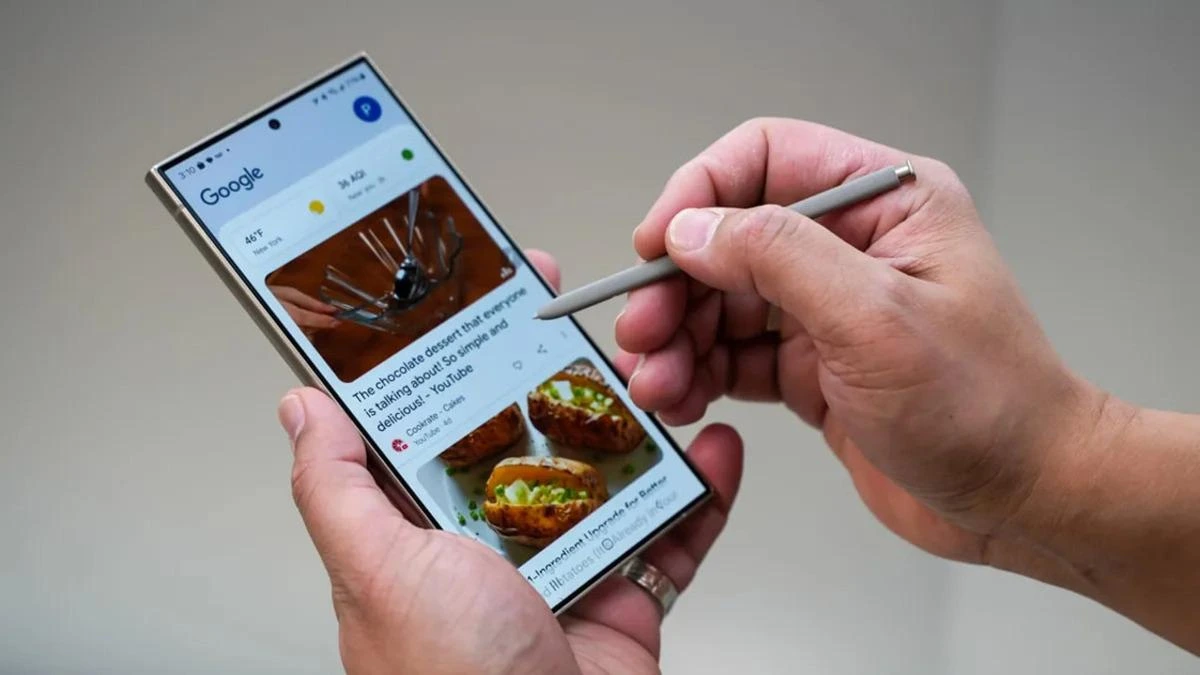 Bir kişi, ekranında Google içerikleri açık olan akıllı telefonu kalemle kullanıyor