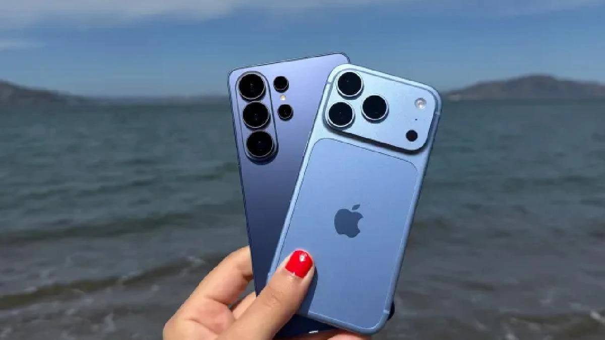 Deniz kıyısında elde tutulan iki akıllı telefon