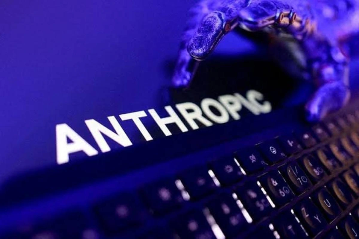 Klavye üzerindeki ekranda Anthropic adı ve mor tonlarda bir el görseli