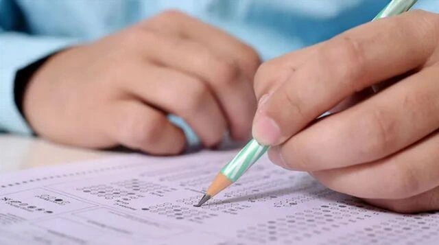 Sınav cevap kâğıdını kalemle dolduran öğrenci