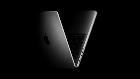Karanlık fonda açık konumda duran Apple dizüstü bilgisayar