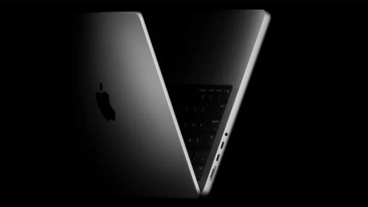 Karanlık fonda açık duran Apple dizüstü bilgisayar