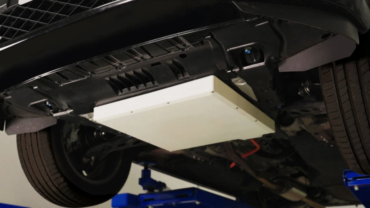 Aracın alt kısmına monte edilmiş dikdörtgen kablosuz enerji alıcı-verici ünitesi