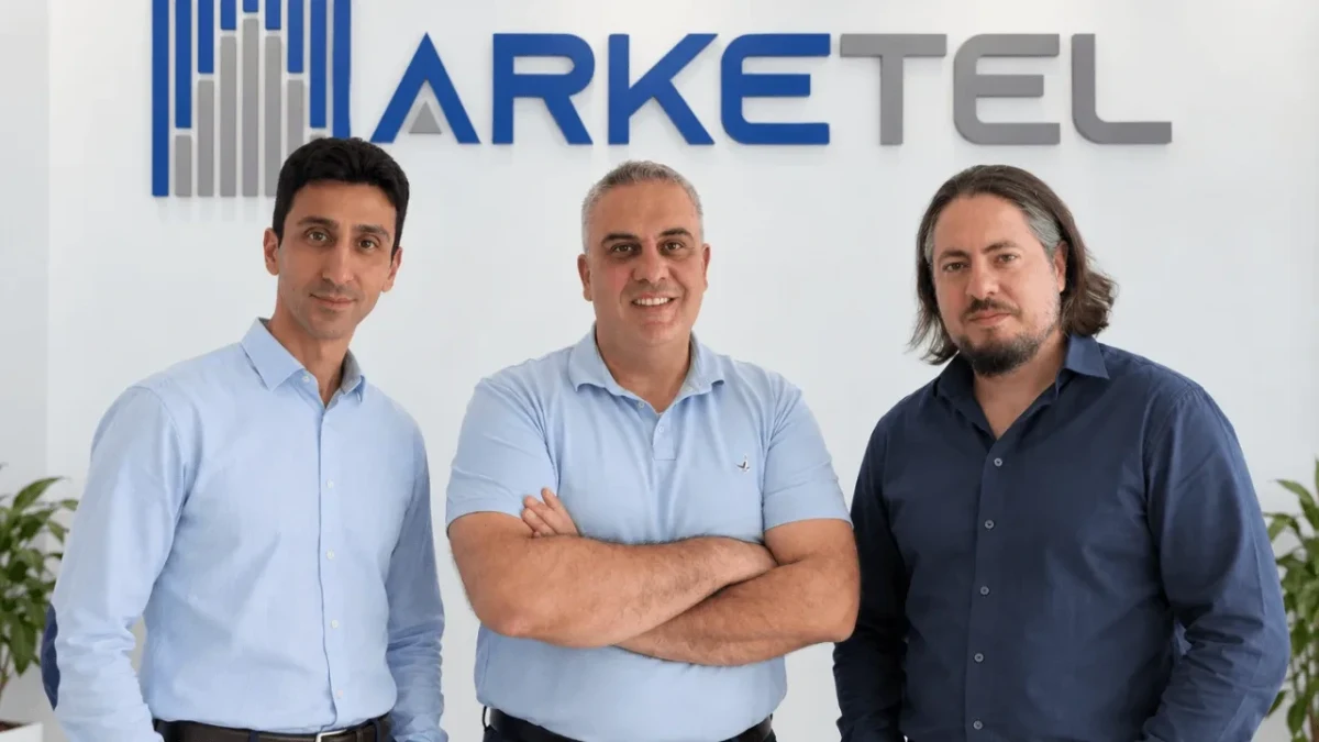 Arke Telekom’un üç yöneticisi şirket logosunun önünde yan yana duruyor.
