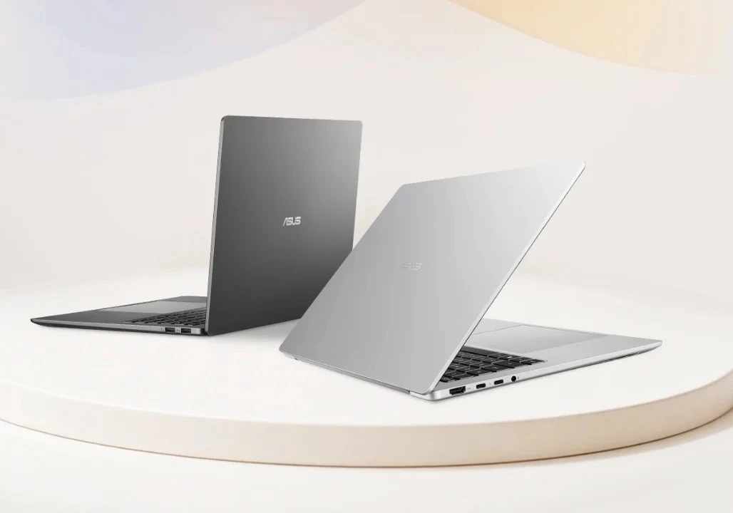 Açık renkli zeminde biri kapalı, diğeri açık iki Asus dizüstü bilgisayar