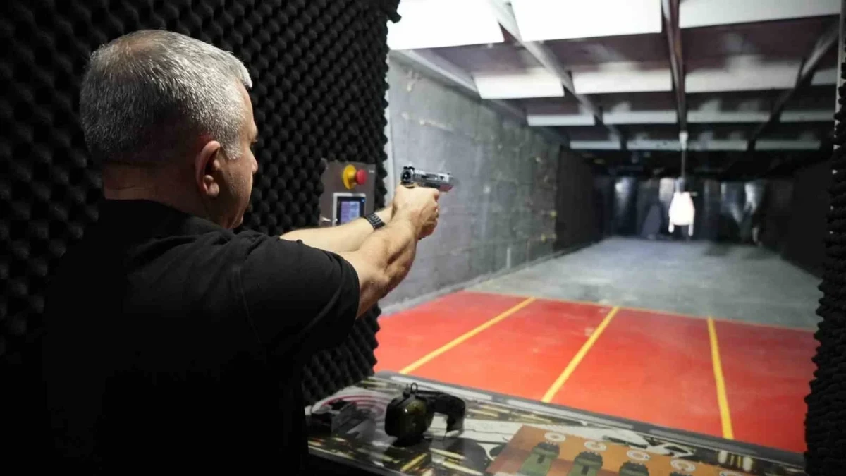 Atış poligonunda hedefe tabancayla ateş eden kişi