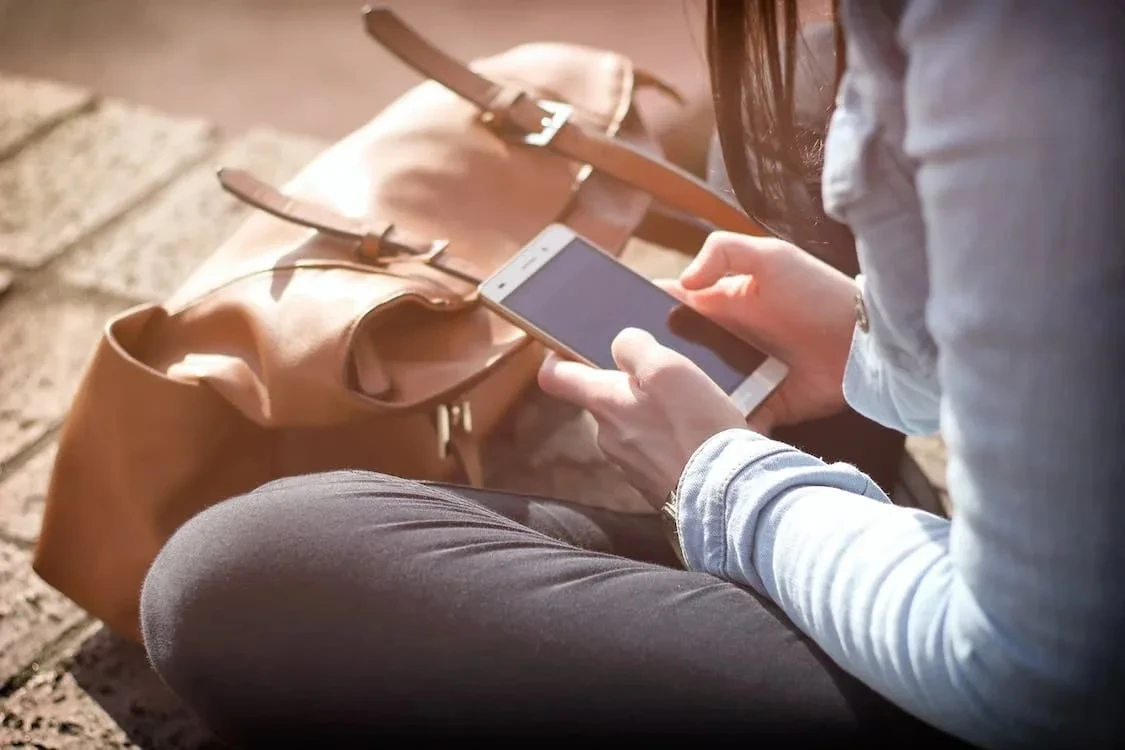 Bir kişi elindeki akıllı telefona bakıyor