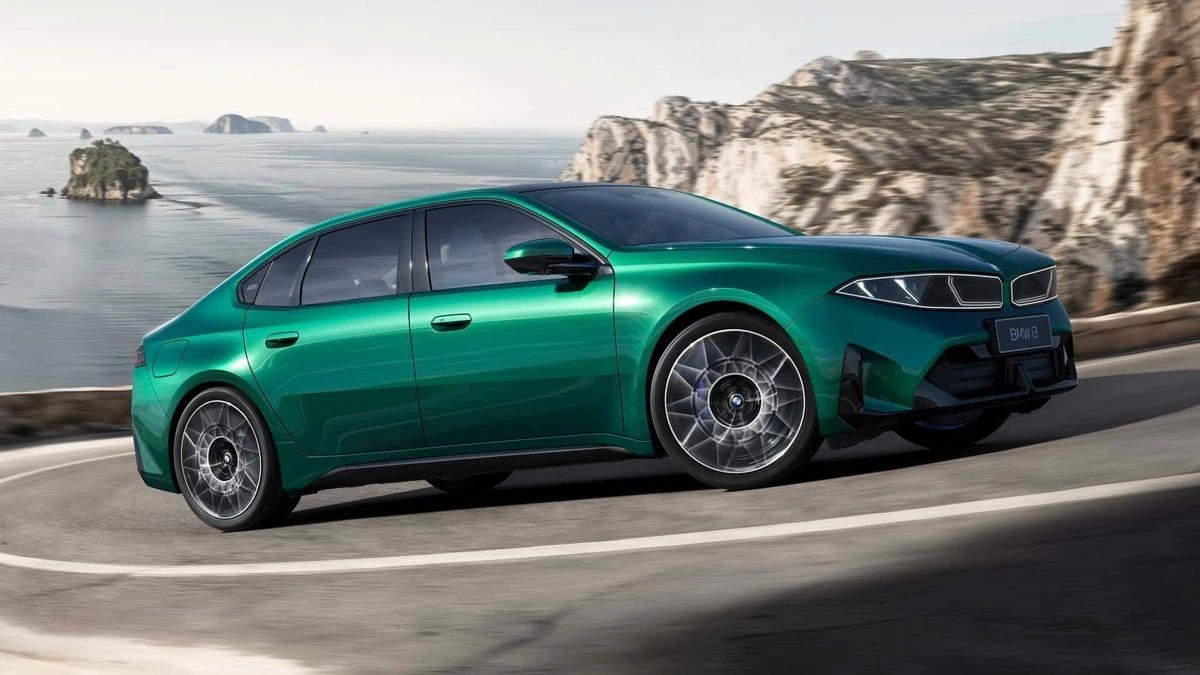 Deniz kıyısındaki yolda ilerleyen yeşil BMW i3 50L