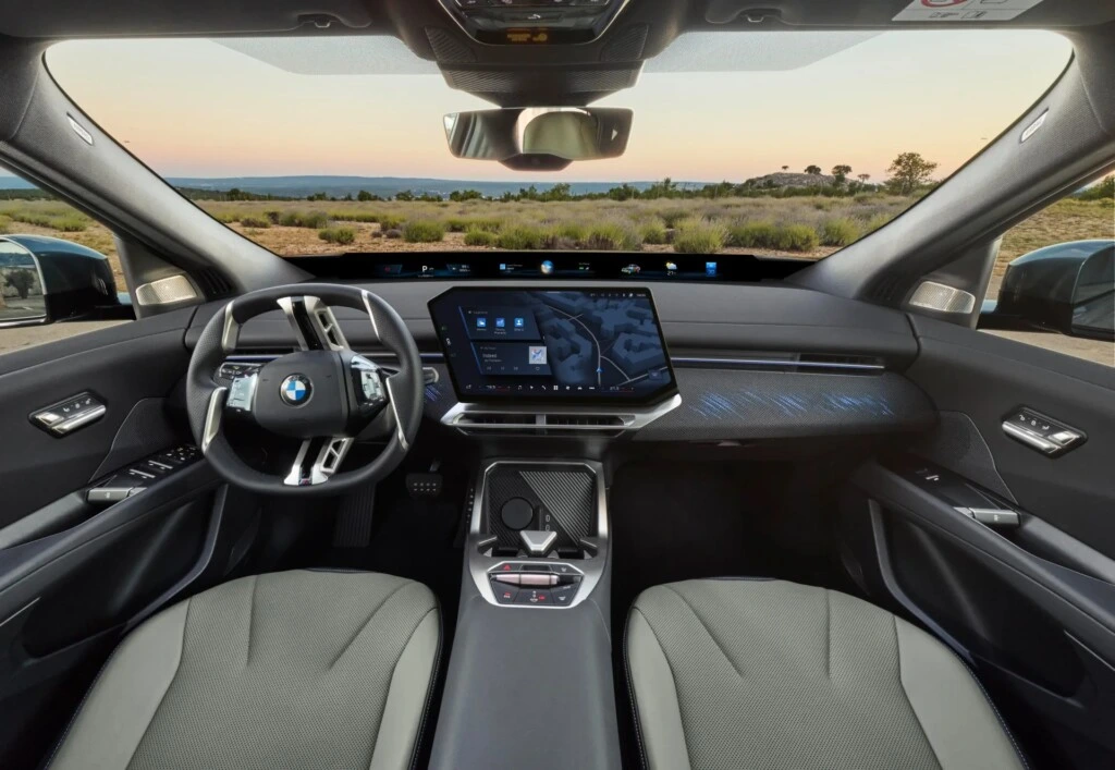 BMW iX4’ün ön konsolu, direksiyonu ve merkezi dokunmatik ekranı