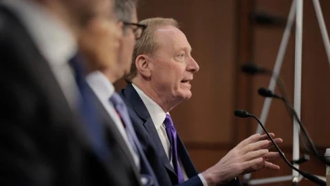 Microsoft Başkanı Brad Smith bir mikrofon önünde konuşurken