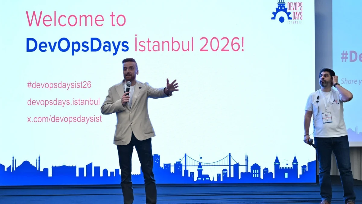 DevOpsDays İstanbul 2026 açılışında iki konuşmacı sahnede katılımcılara sesleniyor