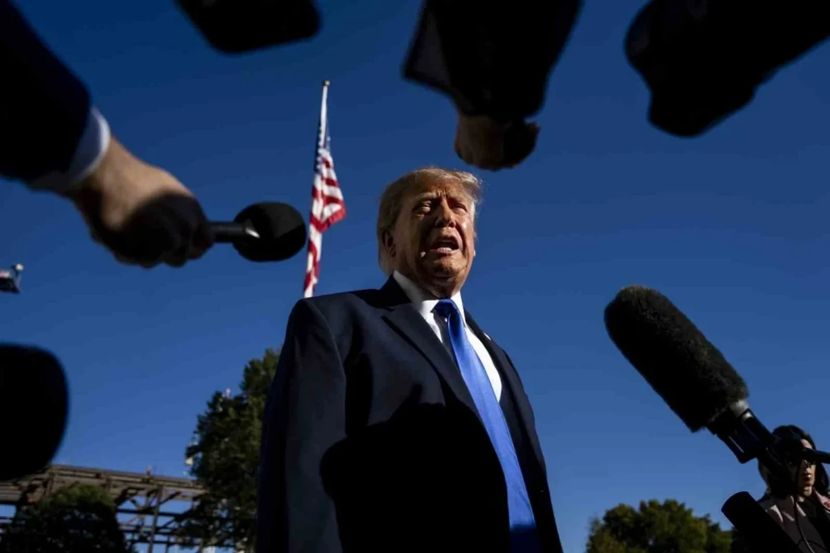 Donald Trump, açık havada mikrofonlarla çevrili şekilde konuşuyor