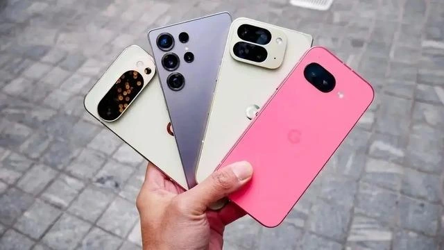 Bir elde tutulan farklı renk ve tasarımlara sahip dört akıllı telefon