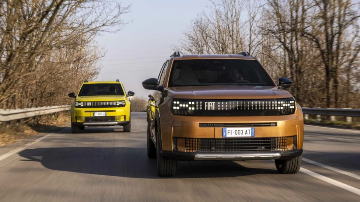 Önde bronz renkli Fiat Grande Panda Elektrikli, arkasında sarı renkli bir Fiat otomobilin bulunduğu yol görüntüsü