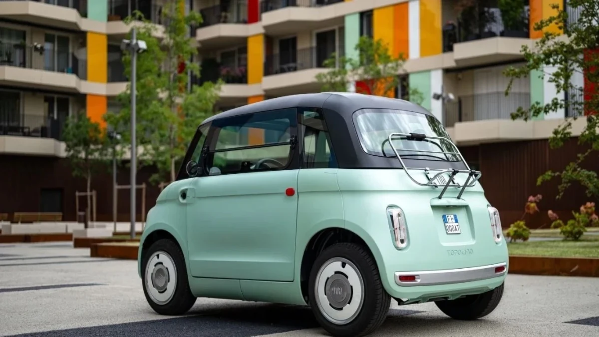 Apartmanların önünde duran açık yeşil renkli küçük Fiat otomobil