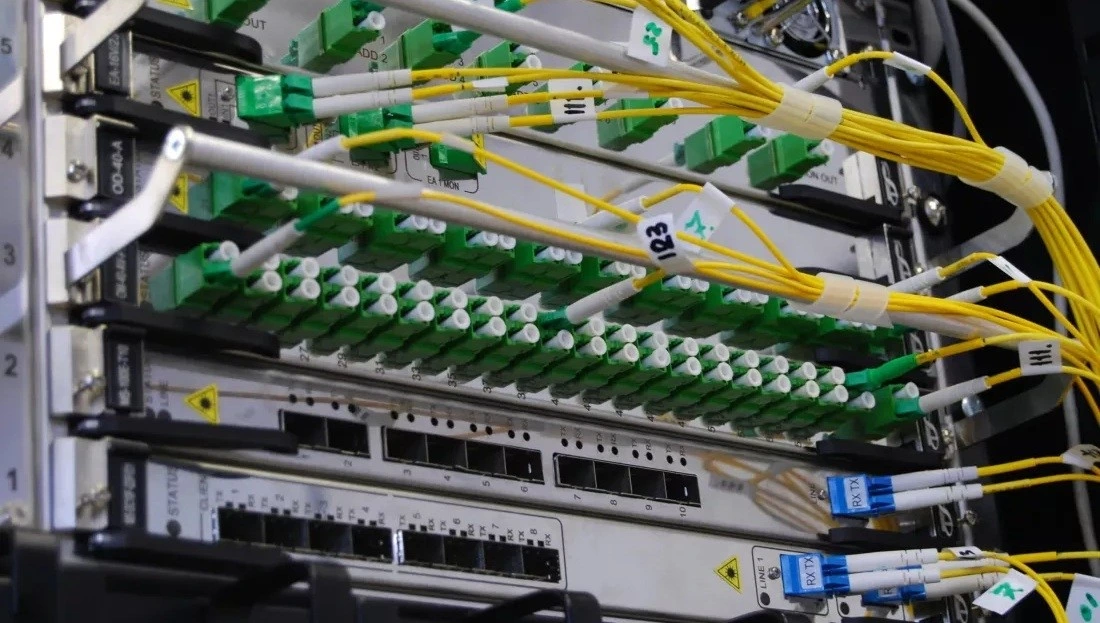 Sarı ve yeşil kabloların bağlı olduğu fiber optik iletişim ekipmanı