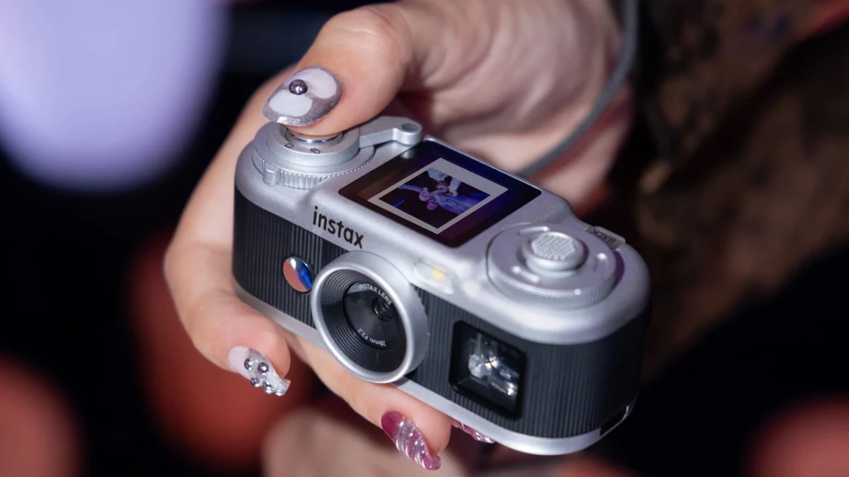 Bir kişinin elinde tuttuğu, LCD ekranlı Fujifilm instax kamera