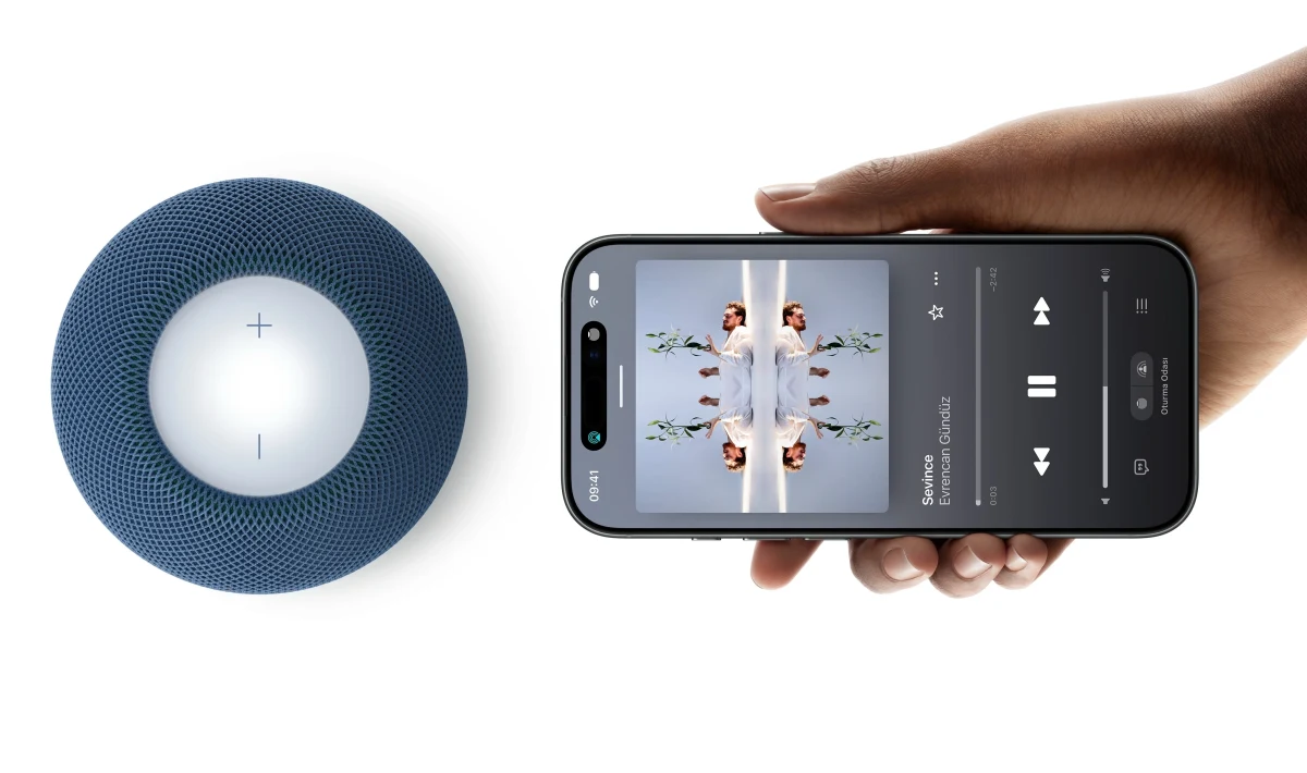 Mavi HomePod mini hoparlörün yanında müzik uygulaması açık bir telefon