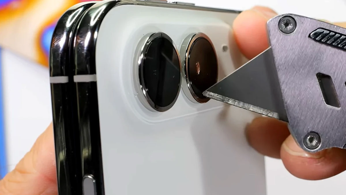 Bir telefonun arka yüzündeki kamera bölgesine metal bir aletle baskı uygulanıyor