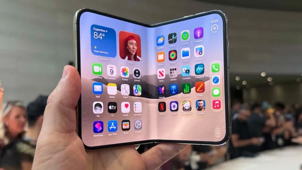 Bir kişinin elinde açık halde tuttuğu, ekranında uygulama simgeleri görünen katlanabilir telefon