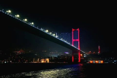 Gece ışıklandırılmış Boğaziçi Köprüsü ve İstanbul silüeti