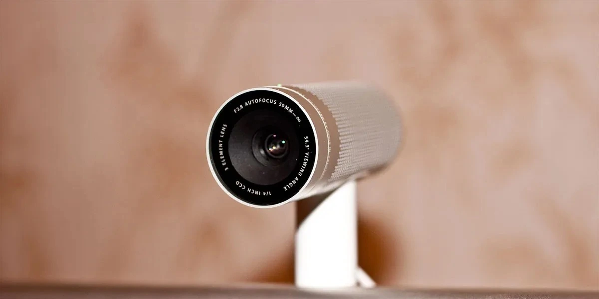 Silindirik, açık renkli akıllı ev kamerasının ön yüzündeki lens