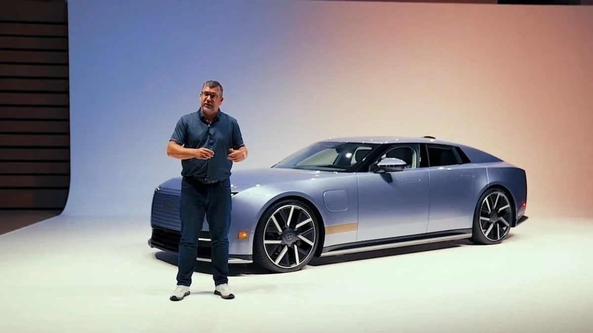 Jaguar Type 01’in yanında duran bir kişi ve otomobilin önden yan görünümü
