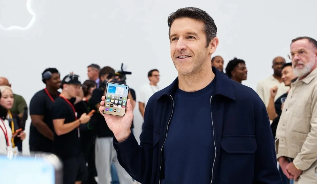 John Ternus bir etkinlikte elinde iPhone tutuyor
