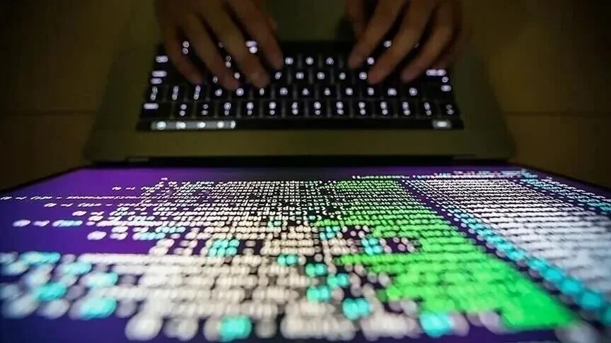 Bilgisayar klavyesinde yazı yazan eller ve ekranda renkli dijital karakterler