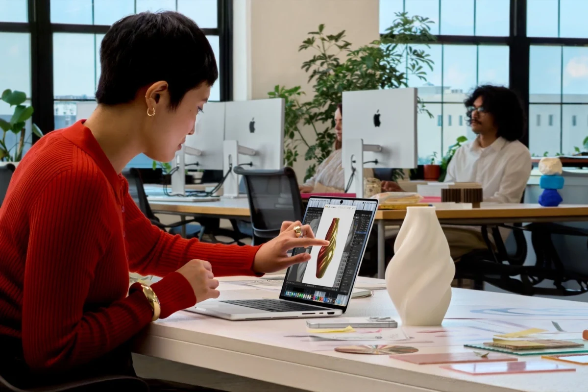 Bir kullanıcı MacBook Pro ekranında tasarım üzerinde dokunarak çalışıyor