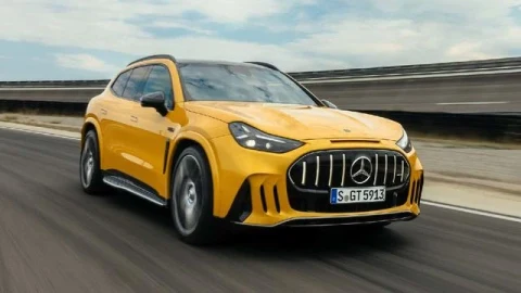 Sarı Mercedes-AMG GT SUV, pistte hareket hâlindeyken önden ve yandan görünüyor