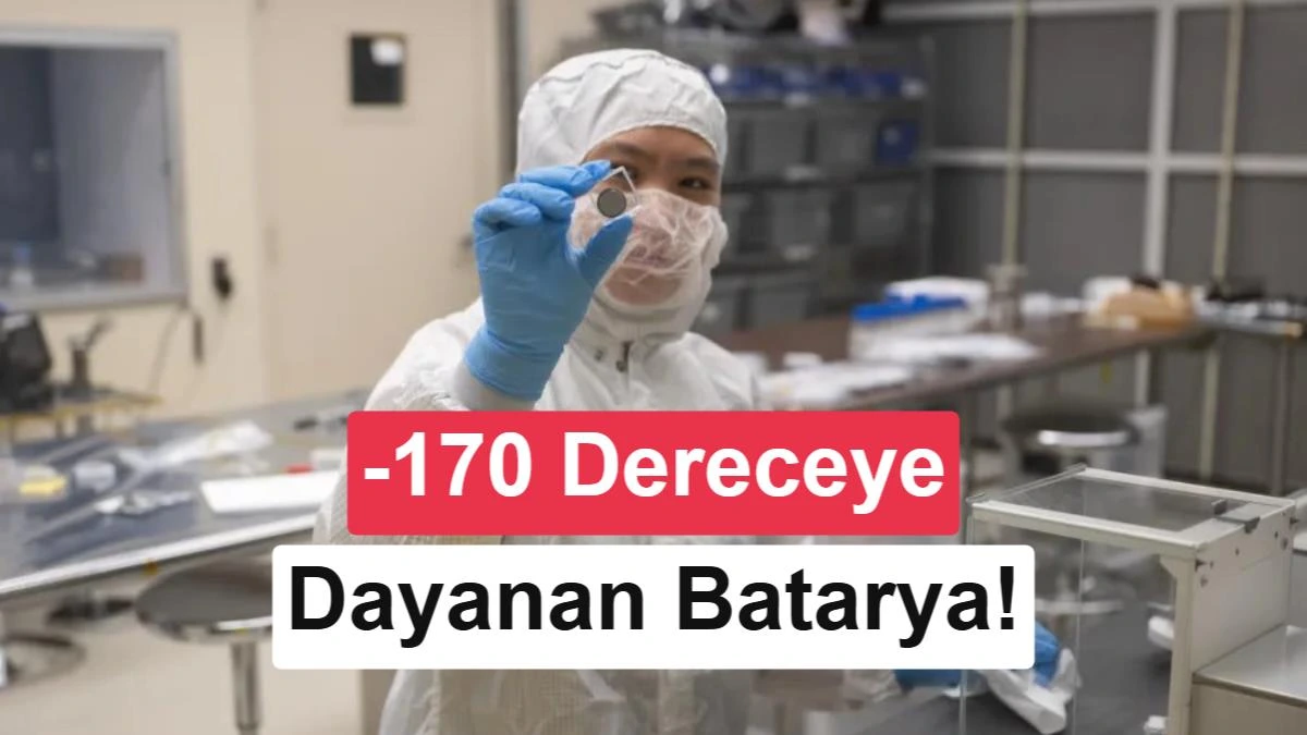 Laboratuvar kıyafetli bir araştırmacı, temiz oda ortamında küçük bir batarya hücresini inceliyor.