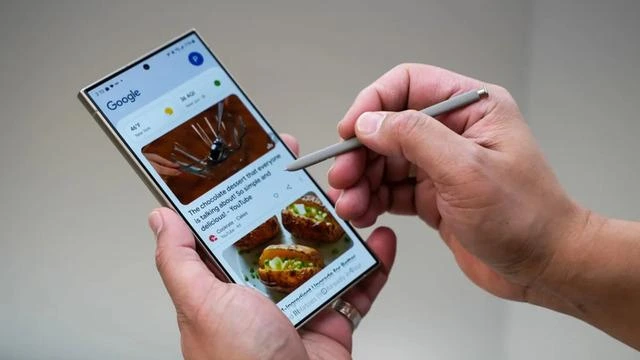 Bir kişi, ekranında Google içerikleri açık olan akıllı telefonu kalemle kullanıyor
