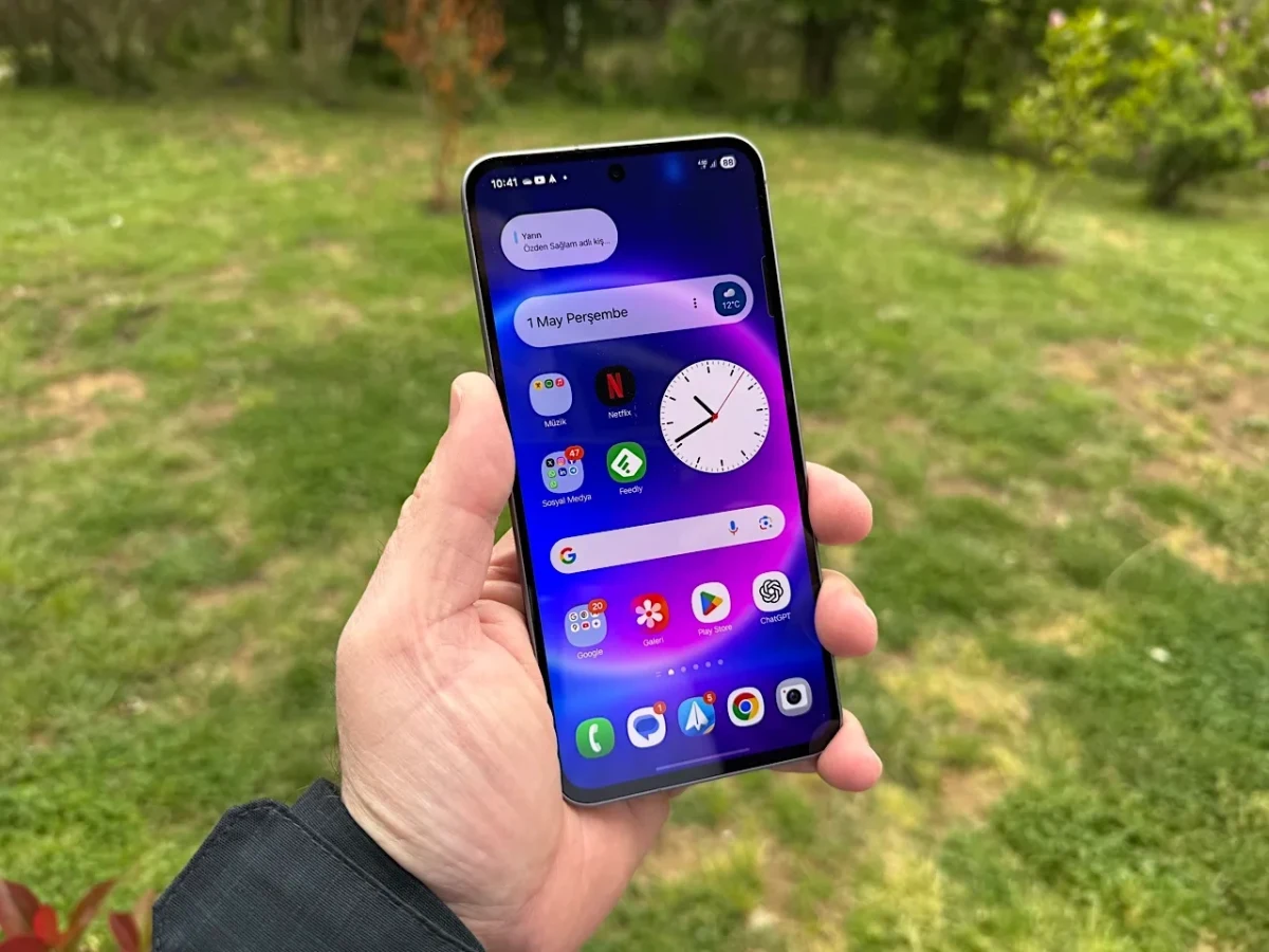 Bir kişinin elinde tuttuğu, ana ekranı açık Samsung Galaxy A serisi telefon