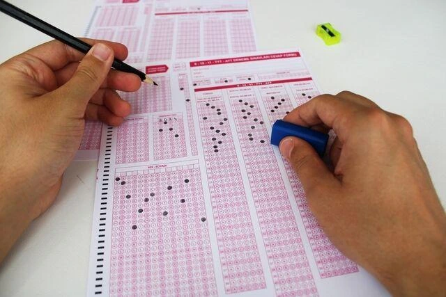 Bir kişi sınav cevap kâğıdındaki seçenekleri kalemle dolduruyor