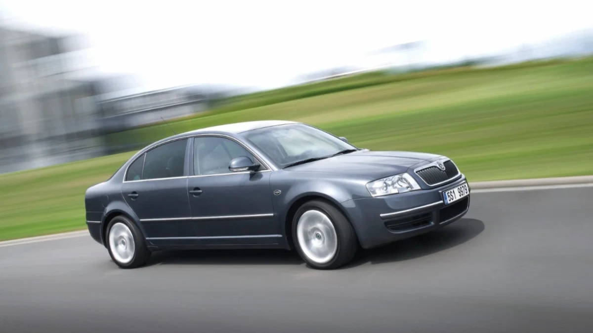 Hareket hâlindeki koyu renkli bir Skoda Superb