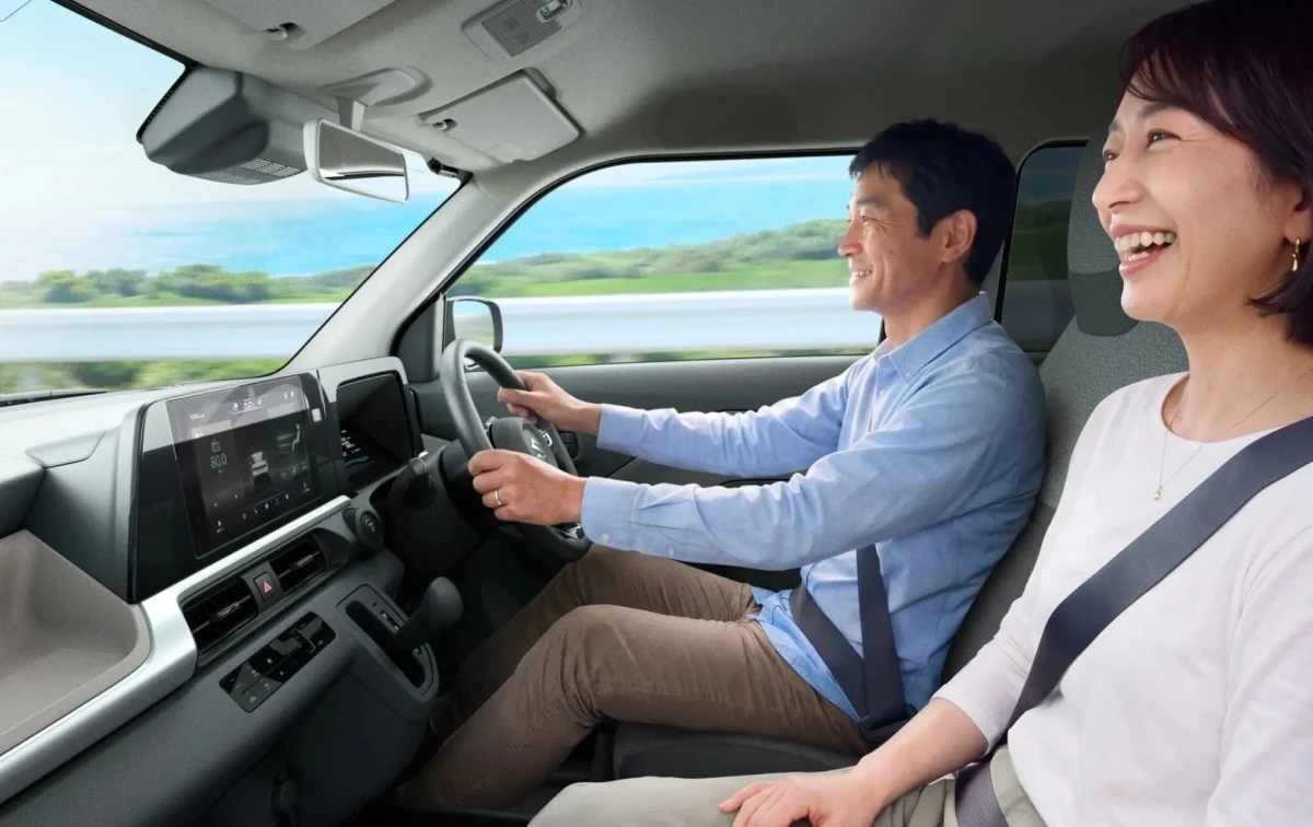 Suzuki e SKY kabininde ön koltuklarda oturan iki kişi