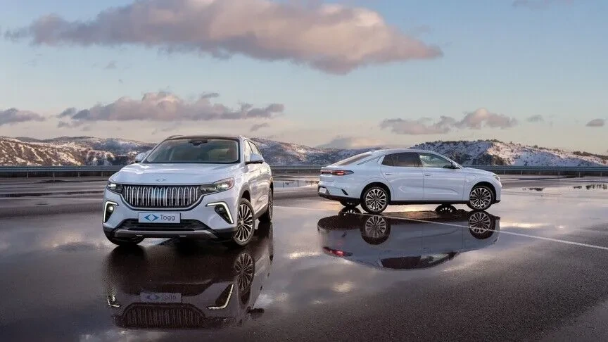 Önde beyaz Togg SUV, arka planda beyaz sedan