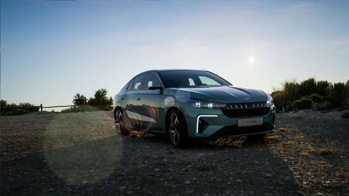 Gün batımına yakın taşlı zeminde duran elektrikli sedan
