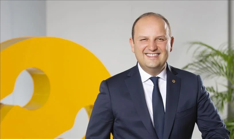 Turkcell logosunun önünde takım elbiseli bir erkek yönetici