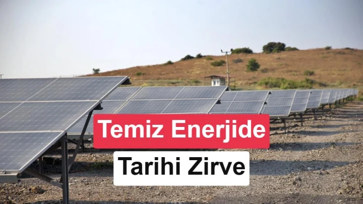 Güneş panellerinin önünde yükselen rüzgâr türbinleri