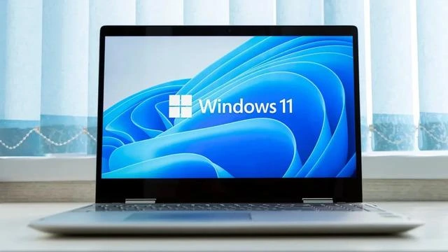 Windows 11 logosu açık bir dizüstü bilgisayar ekranında görünüyor