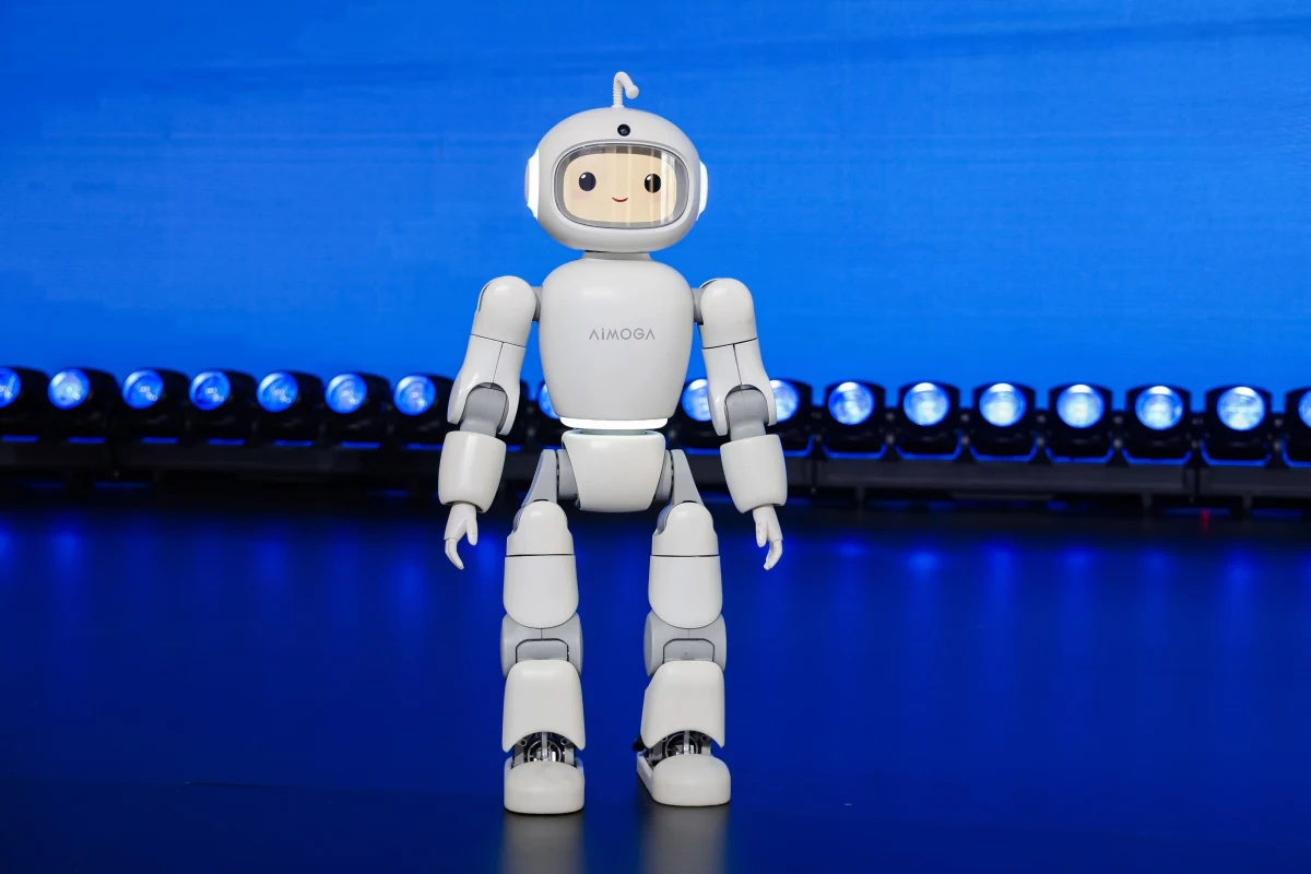 Mavi ışıklarla aydınlatılmış sahnede duran beyaz insansı robot