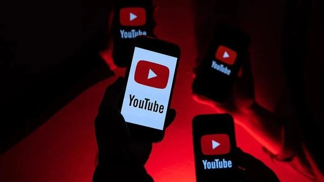 Kırmızı ışık altında YouTube logosu gösteren akıllı telefonlar